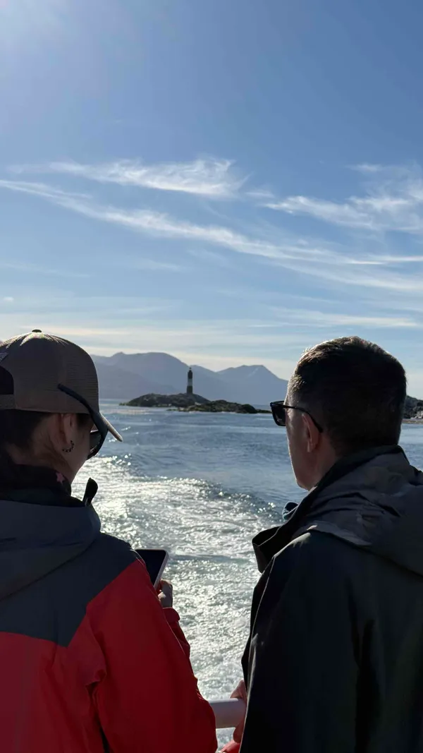 Tourists viewing Beagle Channel and lighthouse from boat