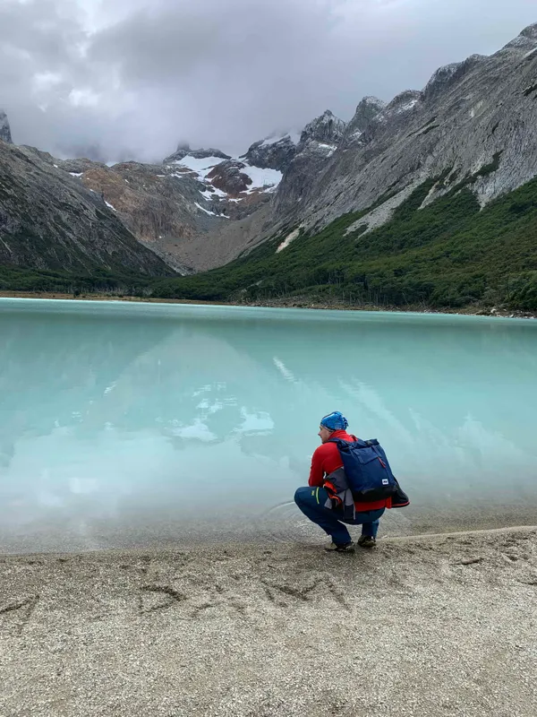Trekker at Laguna Esmeralda lake with Patagonian peaks