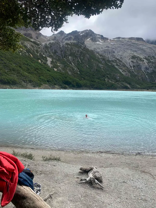 Hiker swimming in Laguna Esmeralda glacial lake