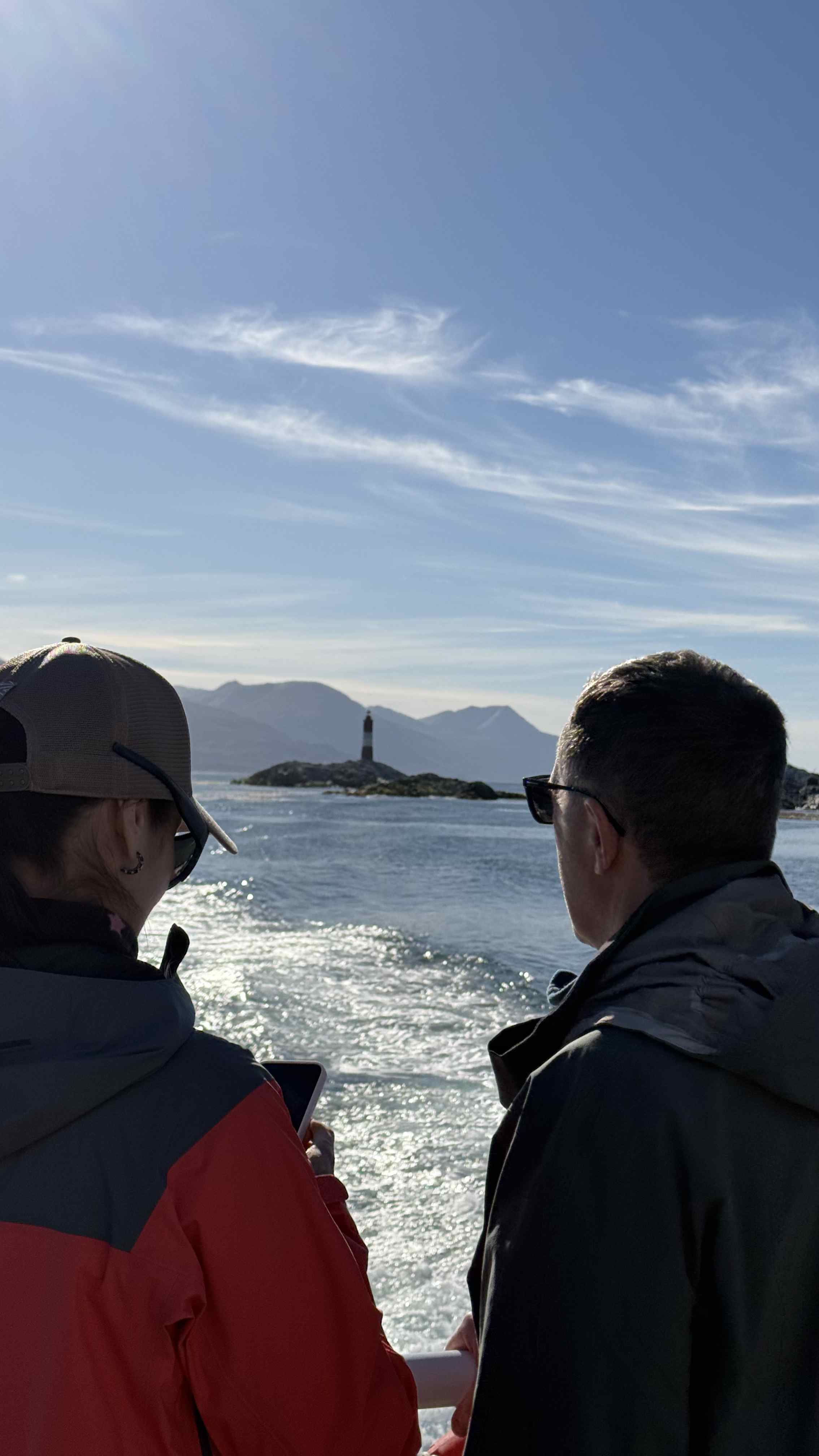 Tourists viewing Beagle Channel and lighthouse from boat