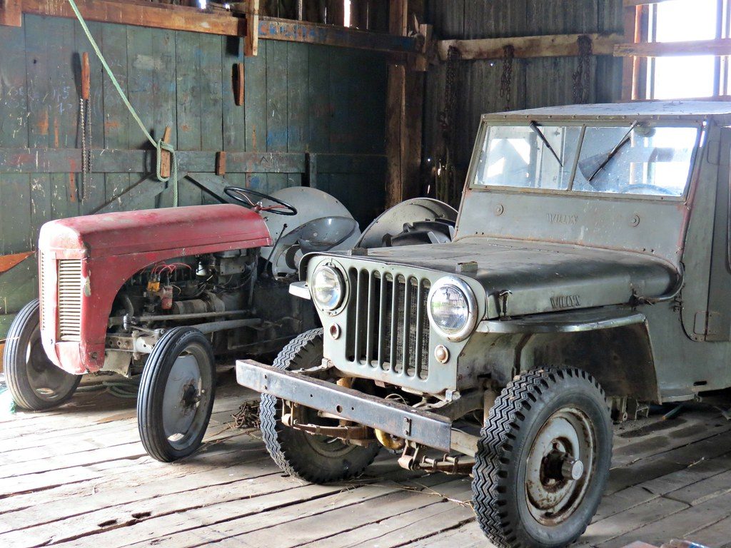 Старый красный трактор и военный Willys jeep в сарае эстансии Harberton