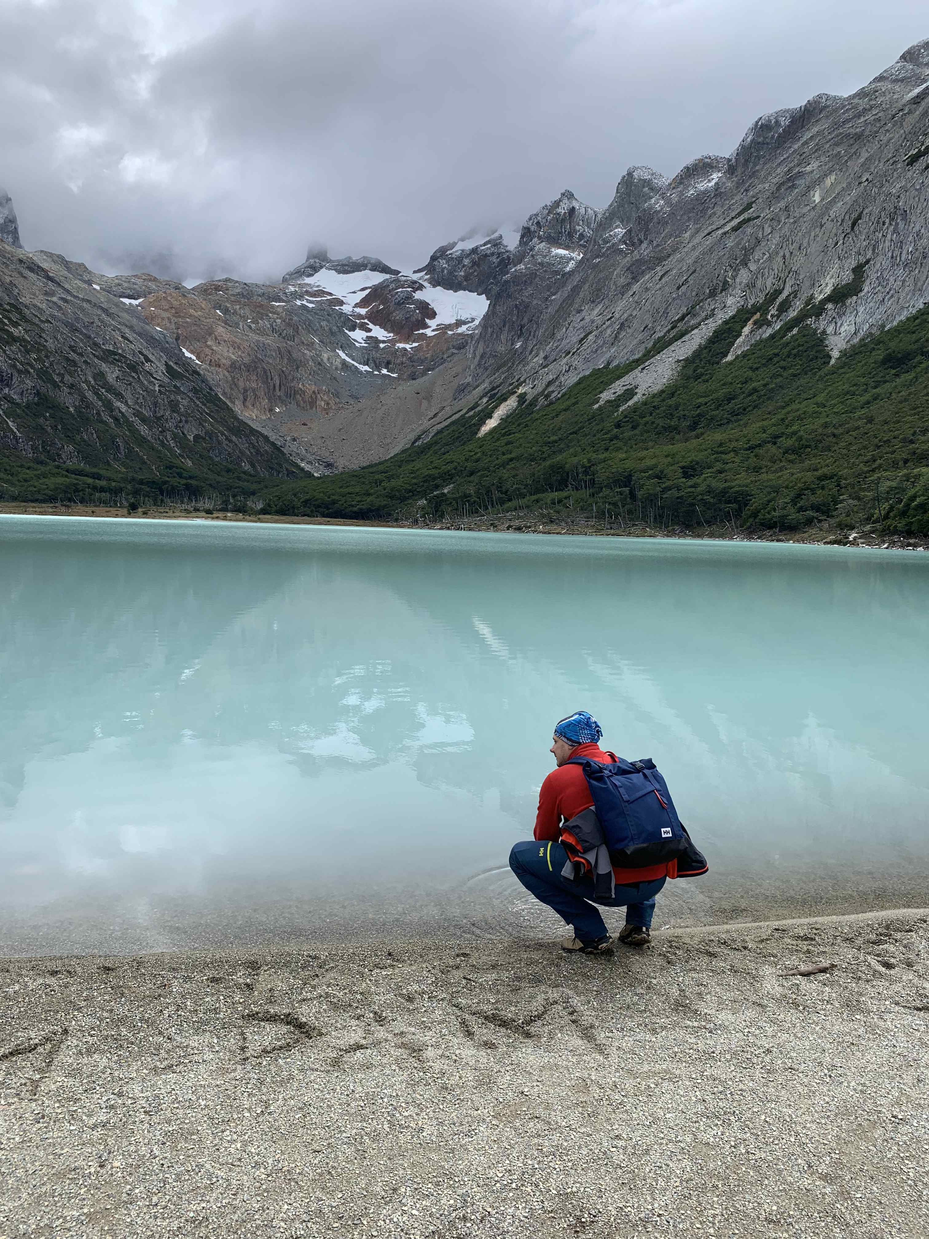 Trekker at Laguna Esmeralda lake with Patagonian peaks