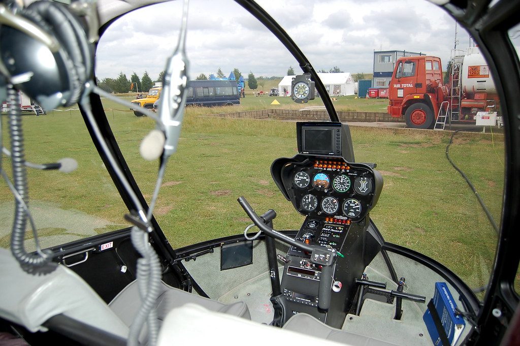 Кабина Robinson R44 с пилотской гарнитурой и видом наружу через стекло