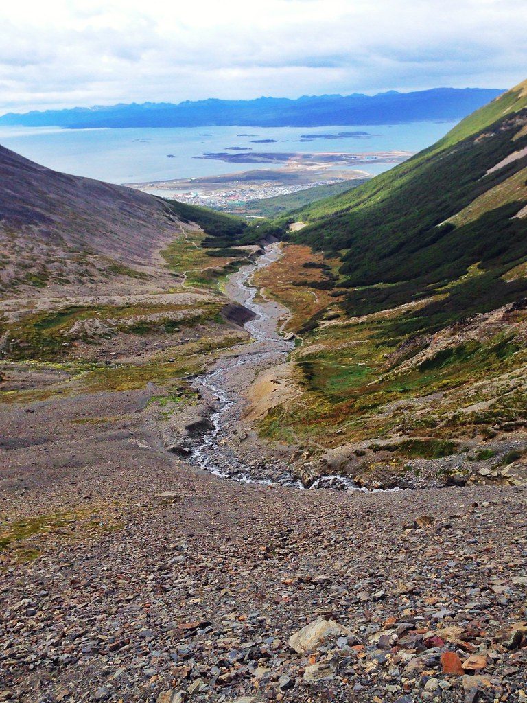 Каменистый поток в долине Glaciar Martial с панорамой Ушуайи и канала Бигля